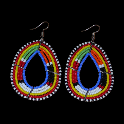 Boucles d'oreilles ethniques multi-rangs à motifs traditionnels Massai composées de perles de rocaille bleues et multicolores glissées sur six rangs de fils de fer montés en forme de gouttes. Elles mesurent 7.5 cm de long et 4 cm de large, et se portent avec des crochets en acier inoxydable sur des oreilles percées.