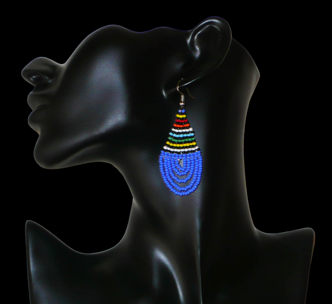 Boucles d'oreilles sud-africaines zouloues en forme de gouttes composées d'un tissage de perles de rocaille bleues et multicolores. Elles mesurent 7 cm de long et 2,5 cm de large et se portent sur des oreilles percées.