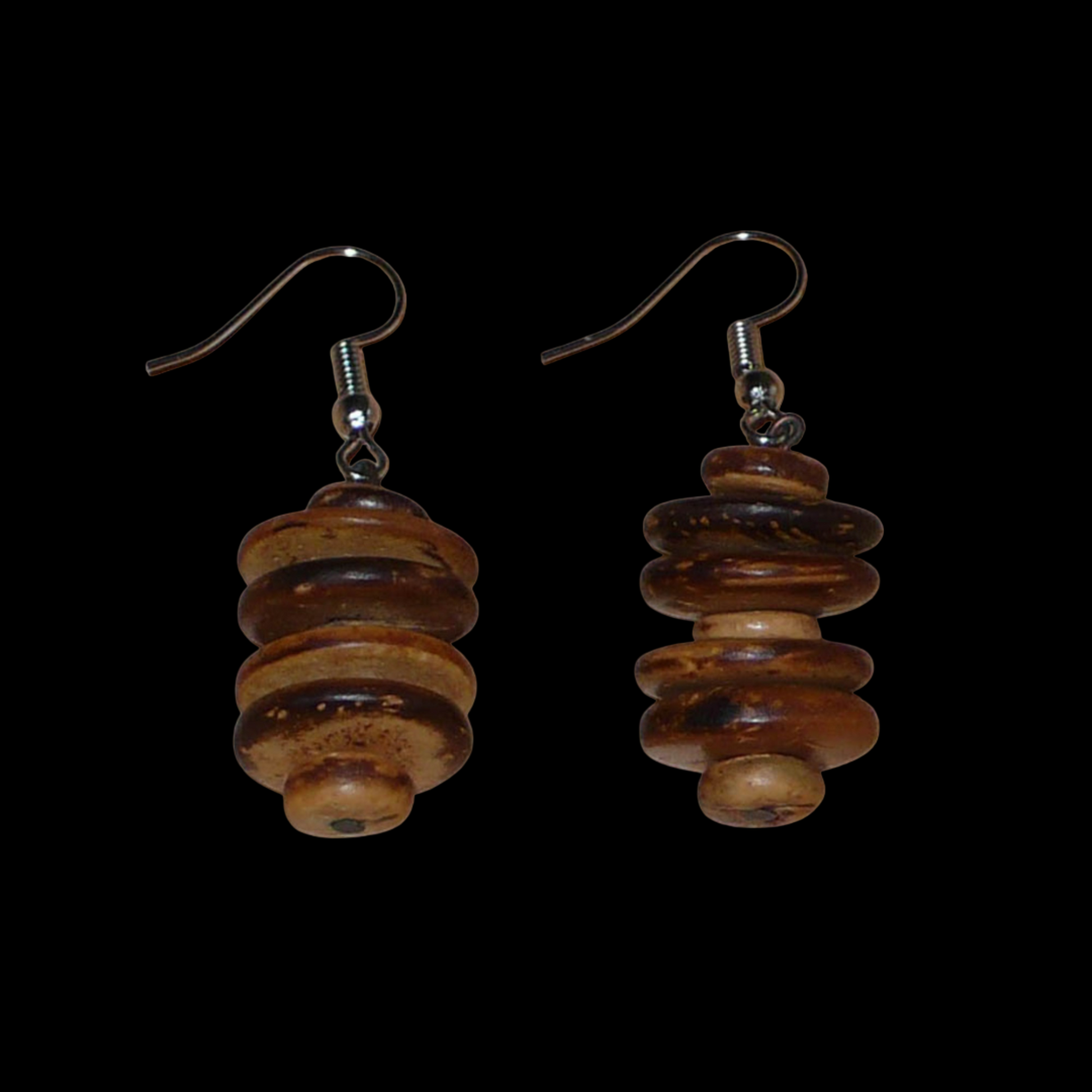 Boucles d'oreilles afro-caribéennes aux accents exotiques composées de perles en noix de coco façonnées en rondelles superposées. De taille moyenne, ces boucles d'oreilles mesurent 4.5 cm de long et 1.5 cm de large ; elles se portent avec des crochets en acier inoxydable sur des oreilles percées.