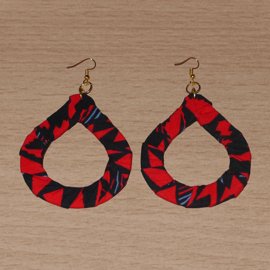 Longues et larges boucles d'oreilles africaines composées de tissu africain rouge et noir avec des touches de gris enroulées sur des structures en forme de gouttes. Elles mesurent 10 cm de long et 6,5 cm de large et se portent avec des crochets en acier inoxydable sur des oreilles percées.