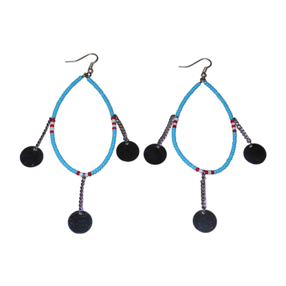Longues boucles d'oreilles africaines Massai composées de perles bleu turquoise, blanches et rouges glissées sur un brin de fil de fer monté en forme de goutte, et de chaînettes ornées de pastilles en métal. Ces boucles d'oreilles ethniques chic mesurent 11,5 cm de long et 4 cm de large, et se portent avec des crochets en acier inoxydable sur des oreilles percées.