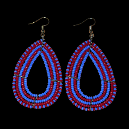 Boucles d'oreilles kenyanes bicolores rouges et bleues en forme de gouttes faites de perles de rocailles. Elles mesurent 8,5 cm de long et 4 cm de large et se portent sur des oreilles percées.
