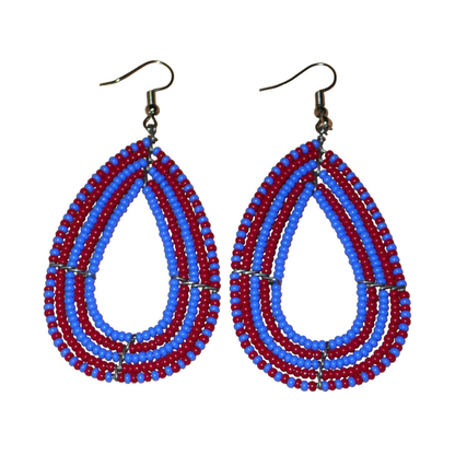 Boucles d'oreilles kenyanes bicolores rouges et bleues en forme de gouttes faites de perles de rocailles. Elles mesurent 8,5 cm de long et 4 cm de large et se portent sur des oreilles percées.