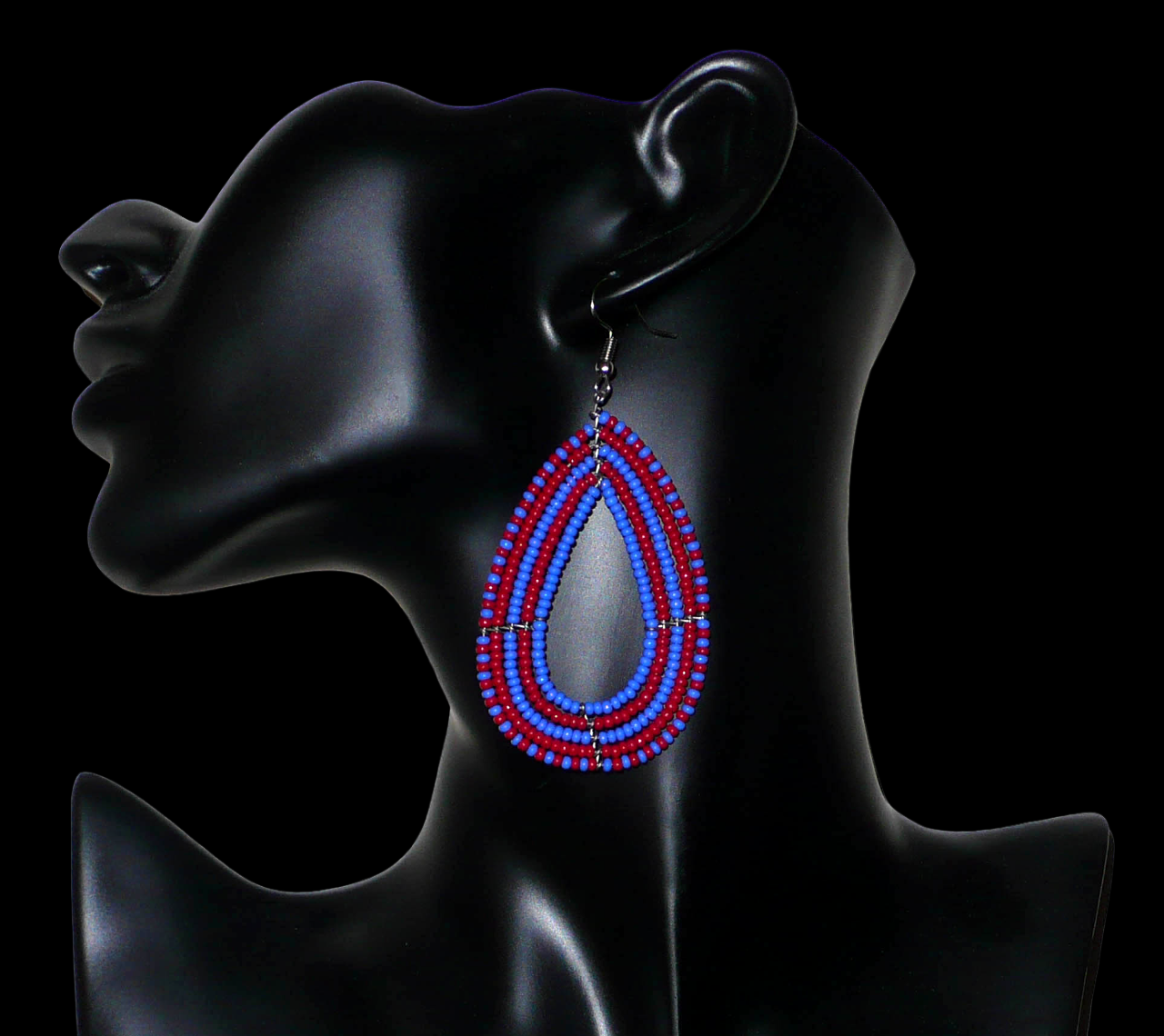 Boucles d'oreilles bicolores en perles de rocaille rouges et bleues enfilées sur cinq rangées de fils de fer montés en forme de gouttes. Elles mesurent 8,5 cm de long et 4 cm de large.