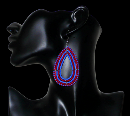 Boucles d'oreilles bicolores en perles de rocaille rouges et bleues enfilées sur cinq rangées de fils de fer montés en forme de gouttes. Elles mesurent 8,5 cm de long et 4 cm de large.