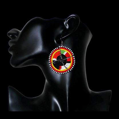 Boucles d'oreilles ethniques rondes composées de perles de rocaille noires et multicolores. De taille moyenne, ces boucles d'oreilles africaines de tradition Massai mesurent 6,5 cm de long et 4,5 cm de large ; elles se portent avec des crochets en acier inoxydable sur des oreilles percées.