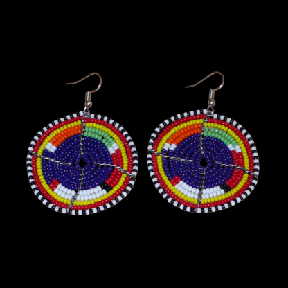 Boucles d'oreilles africaines rondes à motifs ethniques Massai en perles de rocaille bleu foncé et multicolores. Elles mesurent 7 cm de long et 5 cm de large et se portent sur des oreilles percées.