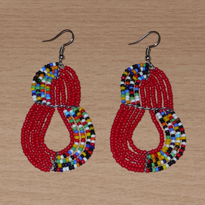 Boucles d'oreilles kenyanes rouges et multicolores en forme de poires composées de perles de rocaille. Elles mesurent 7,5 cm de long et 4 cm de large et se portent sur des oreilles percées.