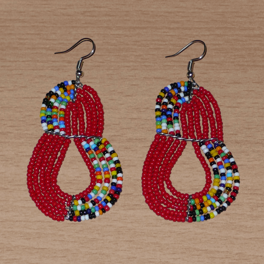 Boucles d'oreilles kenyanes rouges et multicolores en forme de poires composées de perles de rocaille. Elles mesurent 7,5 cm de long et 4 cm de large et se portent sur des oreilles percées.
