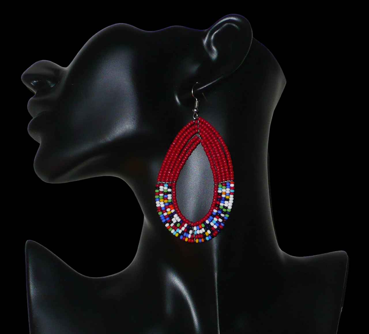 Longues boucles d'oreilles pendantes composées de perles de rocailles rouges et multicolores enfilées sur cinq rangs de fils de fer montés en forme de gouttes. Elles mesurent 9 cm de long et 4,5 cm de large et se portent avec des crochets sur des oreilles percées.