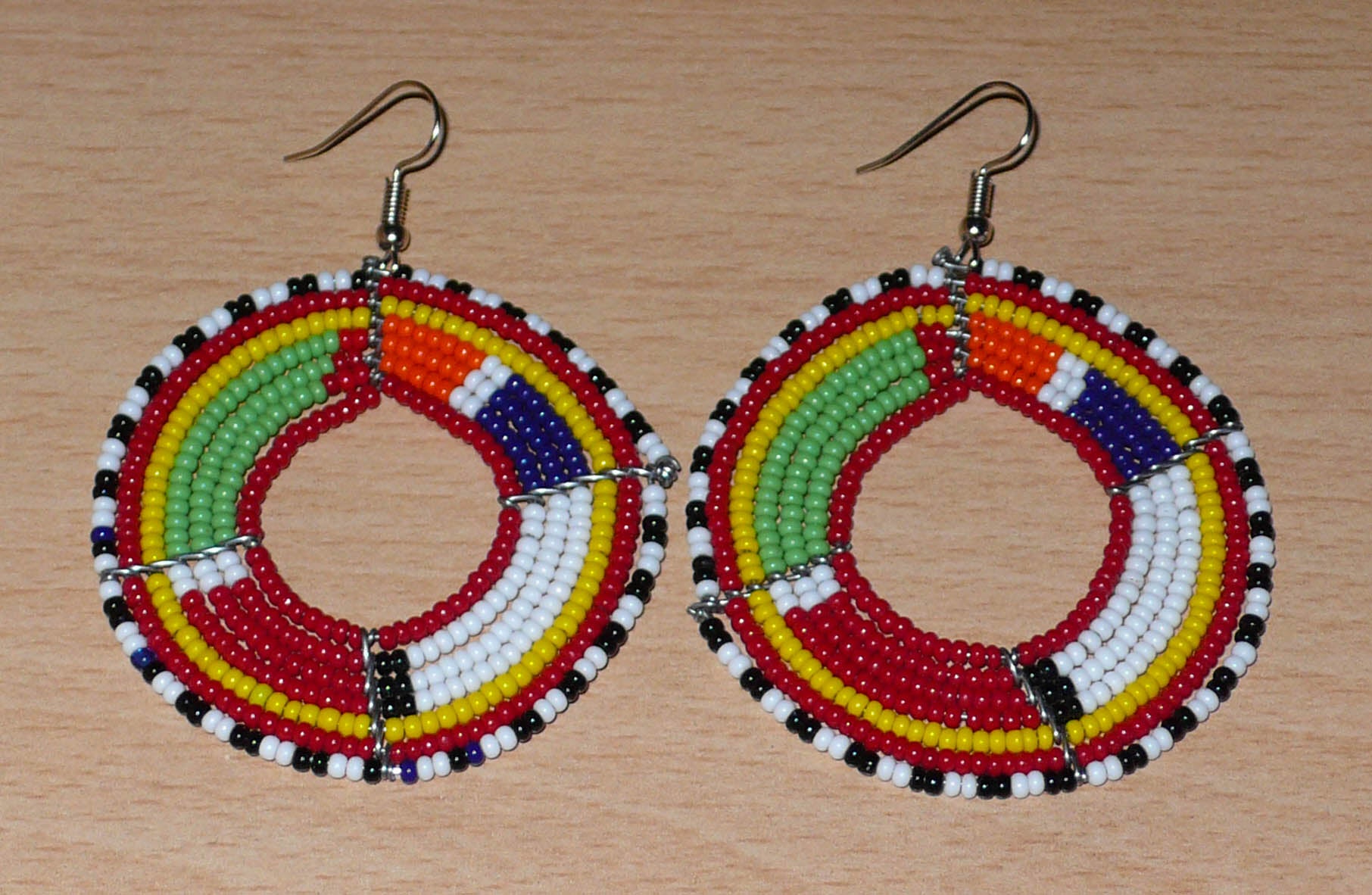 Boucles d'oreilles africaines rondes de tradition Massai faites de perles de rocaille rouges et multicolores.