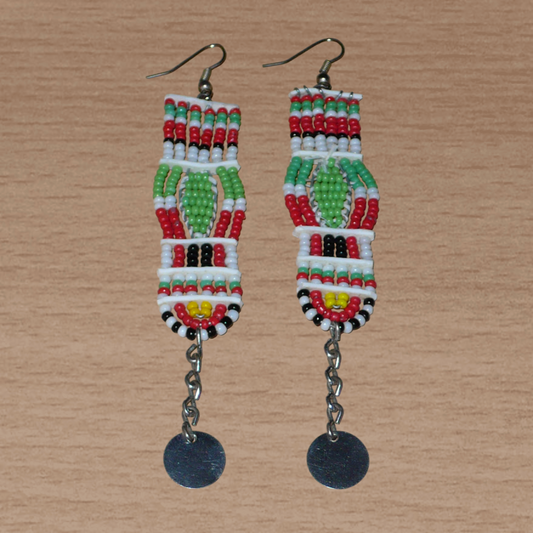 Longues boucles d'oreilles africaines de tradition Massai en perles de rocaille prolongées de chaînettes ornées de disques métalliques. Elles mesurent 11 cm de long et 2,5 cm de large, et se portent avec des crochets en acier inoxydable sur des oreilles percées.