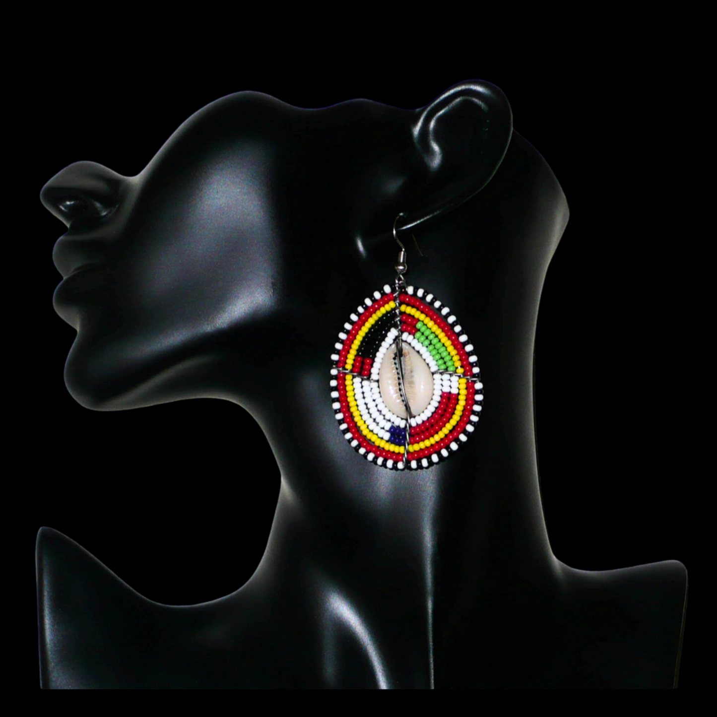 Boucles d'oreilles africaines traditionnelles en forme de boucliers Massai faites de perles et de coquillages cauris ; elles mesurent 7 cm de long et 4 cm de large et se portent sur des oreilles percées.