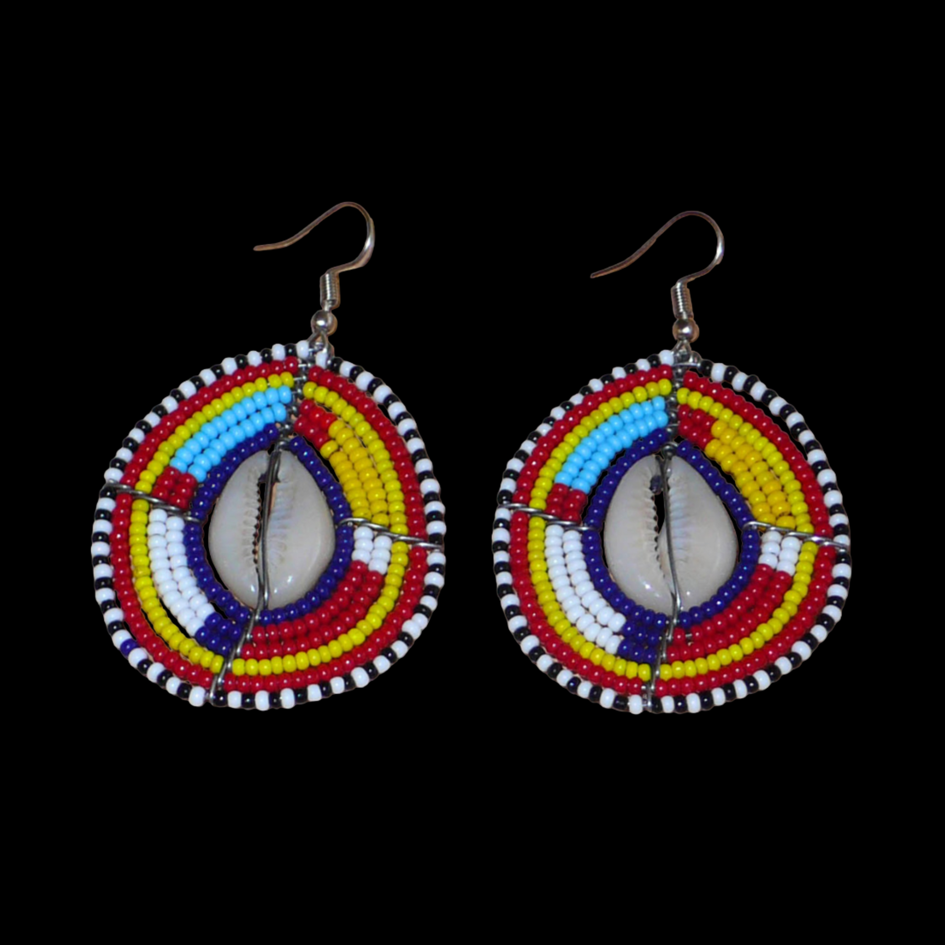 Boucles d'oreilles africaines traditionnelles aux couleurs et motifs ethniques Massai. Elles se composent de perles de rocaille multicolores enfilées sur des fils de fer montés en forme de boucliers Massai ; des coquillages sont incrustés en leur centre. Elles mesurent 7 cm de long et 4 cm de large et se portent avec des crochets en acier inoxydable sur des oreilles percées.