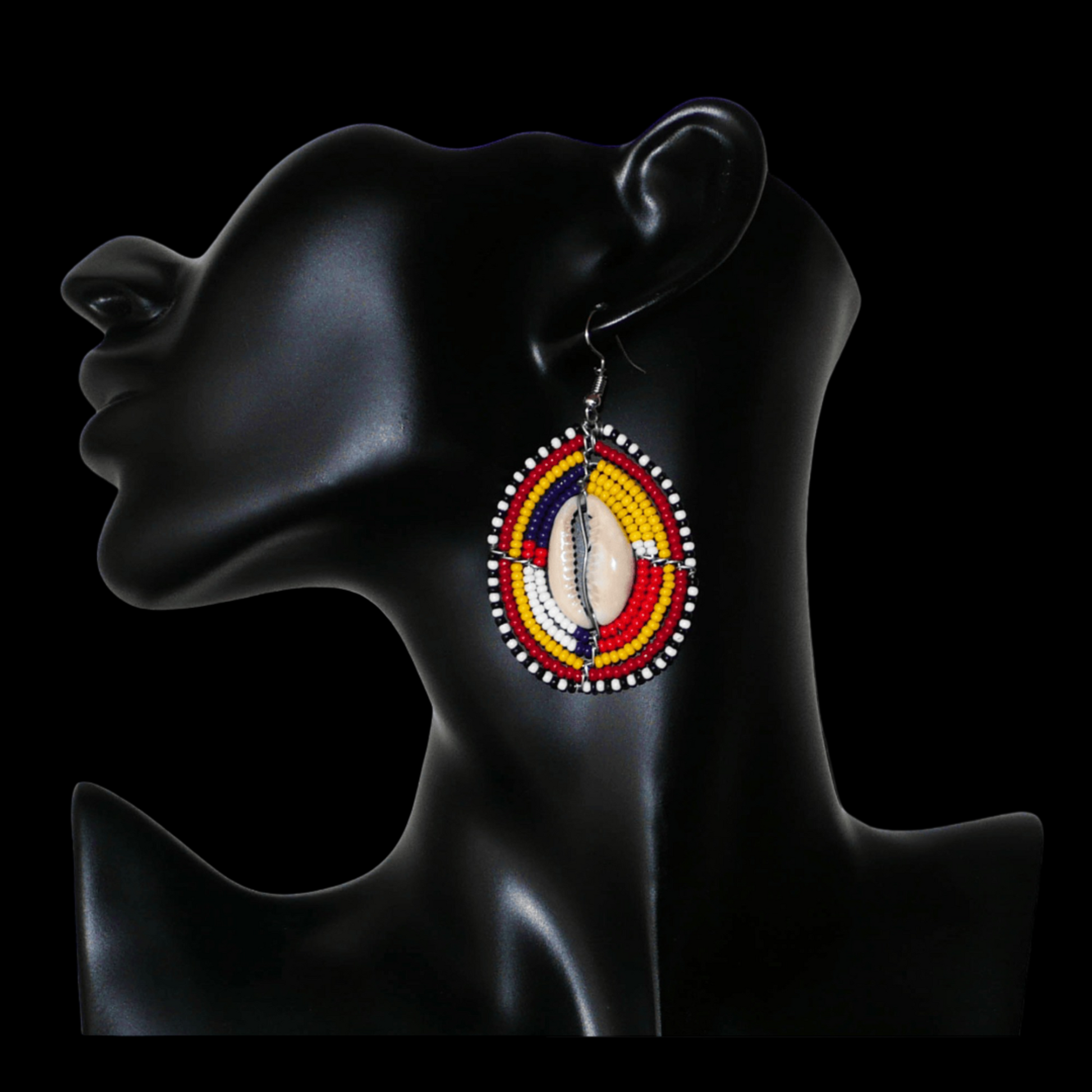 Boucles d'oreilles africaines ethniques en forme de boucliers Massai composées de perles et de coquillages cauris. De taille moyenne, elles mesurent 6,5 cm de long et 3,5 cm de large.