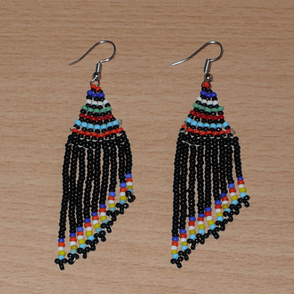 Boucles d'oreilles ethniques de tradition sud-africaine à franges perlées composées de perles de rocaille noires et multicolores. Elles mesurent 8,5 cm de long et 2 cm de large et se portent avec des crochets en acier inoxydable sur des oreilles percées.