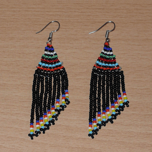 Boucles d'oreilles ethniques de tradition sud-africaine à franges perlées composées de perles de rocaille noires et multicolores. Elles mesurent 8,5 cm de long et 2 cm de large et se portent avec des crochets en acier inoxydable sur des oreilles percées.