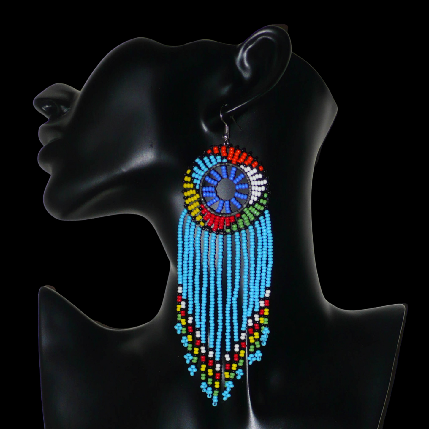 Longues boucles d'oreilles sud-africaines traditionnelles à franges et motifs zoulous composées de perles de rocaille bleu ciel et multicolores. Elles mesurent 14,5 cm de long et 4,5 cm de large, et se portent avec des crochets en acier inoxydable sur des oreilles percées.