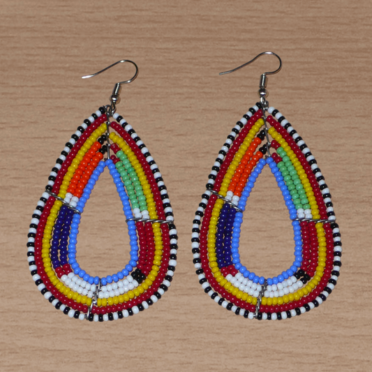 Longues boucles d'oreilles africaines Massai en forme de gouttes composées de perles de rocaille bleues et multicolores. Elles mesurent 8,5 cm de long et 4 cm de large et se portent avec des crochets en acier inoxydable sur des oreilles percées.