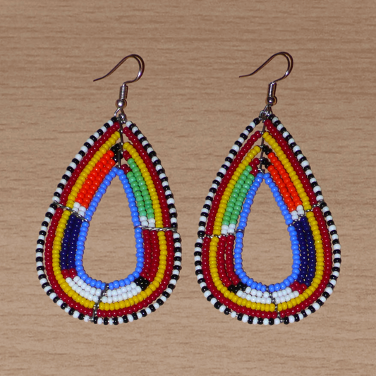Longues boucles d'oreilles africaines Massai en forme de gouttes composées de perles de rocaille bleues et multicolores. Elles mesurent 8,5 cm de long et 4 cm de large et se portent avec des crochets en acier inoxydable sur des oreilles percées.