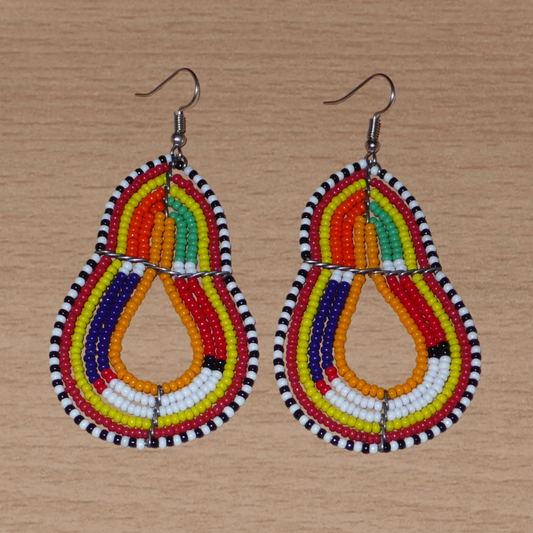Symbole de la richesse culturelle du Kenya, cette paire de boucles d'oreilles africaines à motifs ethniques traditionnels Massai apportera un éclat de couleurs à votre look ! Confectionnées de façon artisanale, elles se composent de perles de rocaille orange et multicolores enfilées sur des structures en fils de fer montés en forme de poires. Elles mesurent 8.5 cm de long et 4 cm de large et se portent sur des oreilles percées.