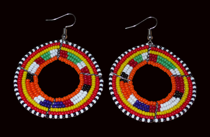 Boucles d'oreilles africaines Massai aux accents afro chic des années 70 composées de perles de rocaille orange et multicolores glissées sur des structures circulaires en fils de fer. De taille moyenne, elles mesurent 7 cm de long et 5 cm de large, et se portent sur des oreilles percées.