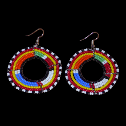 Boucles d'oreilles africaines traditionnelles Massai en perles de rocaille multicolores montées en forme de cercles. Elles mesurent  7 cm de long sur 5 cm de large.