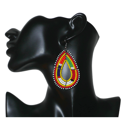 Boucles d'oreilles africaines Massai en perles de rocaille jaunes et multicolores montées en forme de gouttes. Elles mesurent 8 cm de long et 4 cm de large et se portent avec des crochets en acier inoxydable sur des oreilles percées.