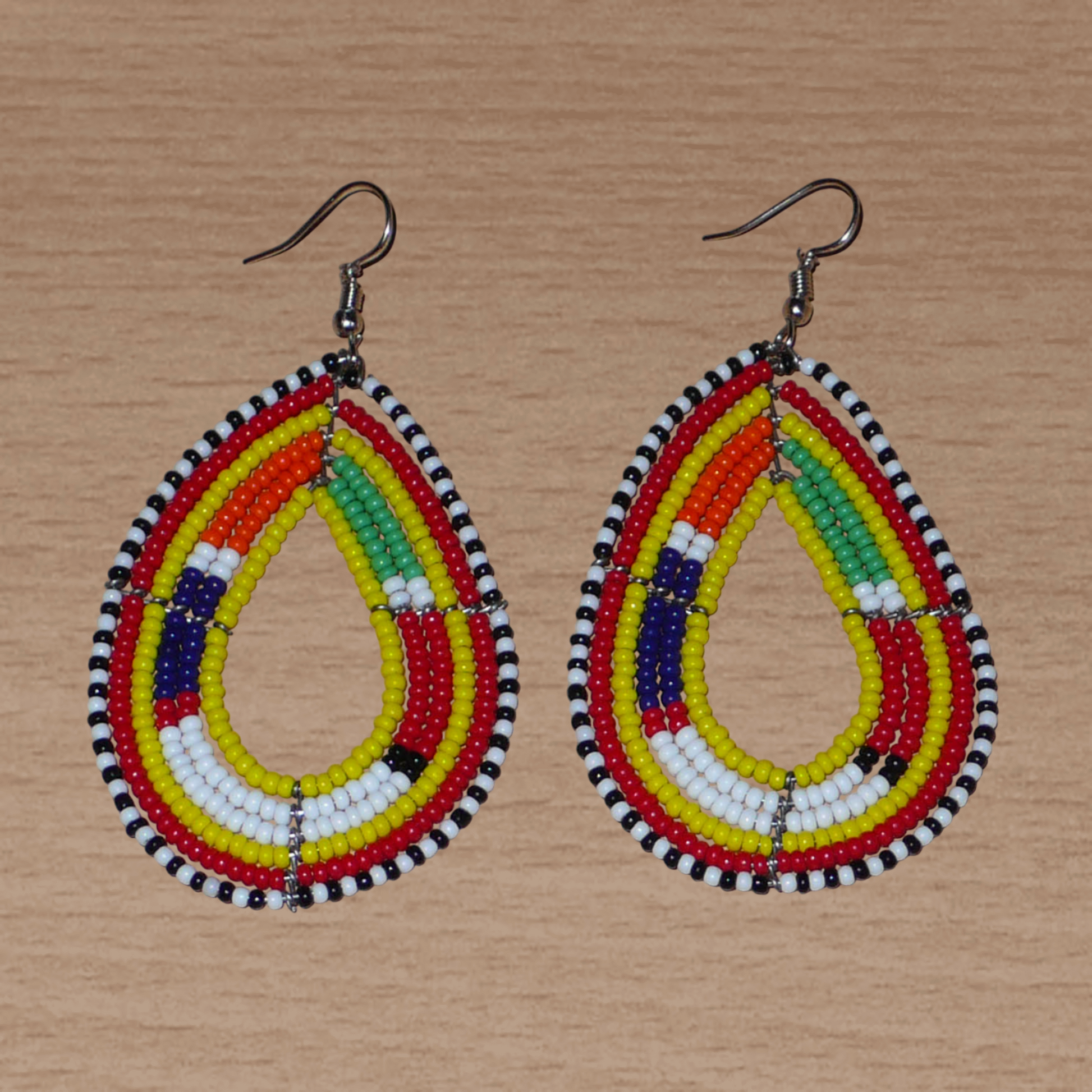 Boucles d'oreilles africaines Massai en perles de rocaille jaunes et multicolores montées en forme de gouttes. Elles mesurent 8 cm de long et 4 cm de large et se portent avec des crochets en acier inoxydable sur des oreilles percées.