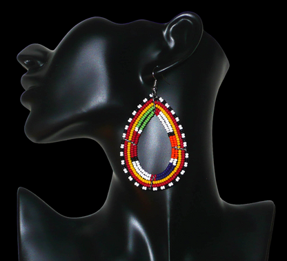 Boucles d'oreilles africaines ethniques Massai en perles de rocaille multicolores montées en forme de gouttes. Ces boucles d'oreilles colorées mesurent 8,5 cm de long et 4,5 cm de large et se portent avec des crochets en acier inoxydable sur des oreilles percées.