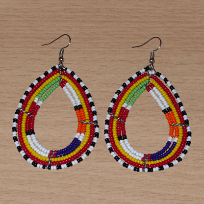 Boucles d'oreilles africaines ethniques Massai en perles de rocaille multicolores montées en forme de gouttes. Ces boucles d'oreilles colorées mesurent 8,5 cm de long et 4,5 cm de large et se portent avec des crochets en acier inoxydable sur des oreilles percées.