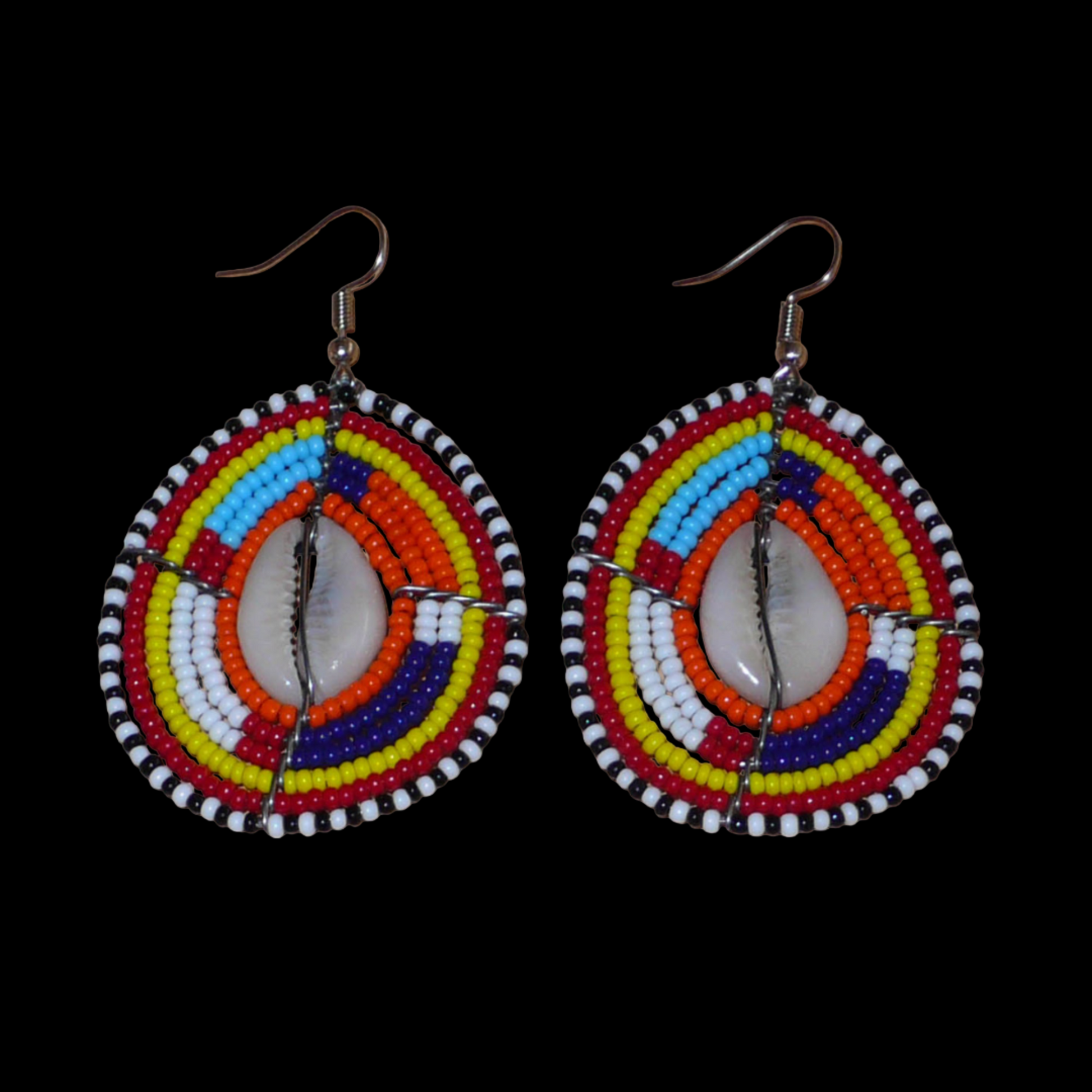 Boucles d'oreilles africaines Massai composées de perles de rocaille multicolores et de coquillages cauris. Elles mesurent 7 cm de long et 4 cm de large et se portent avec des crochets en acier inoxydable sur des oreilles percées.