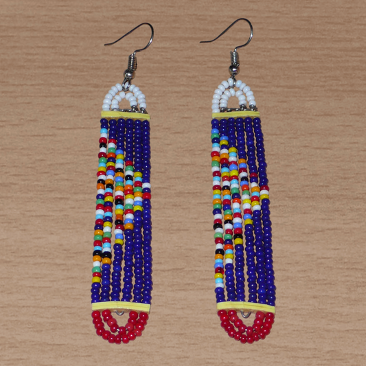 Longues boucles d'oreilles africaines composées de perles de rocaille bleu-blanc-rouge et multicolores enfilées sur six rangées de fils de fer montés en forme de rectangles aux extrémités arrondies. Elles mesurent 9,5 cm de long et 1,5 cm de large, et se portent avec des crochets sur des oreilles percées.