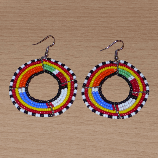 Boucles d'oreilles africaines traditionnelles Massai en perles de rocaille multicolores montées en forme de cercles. Elles mesurent  7 cm de long sur 5 cm de large.