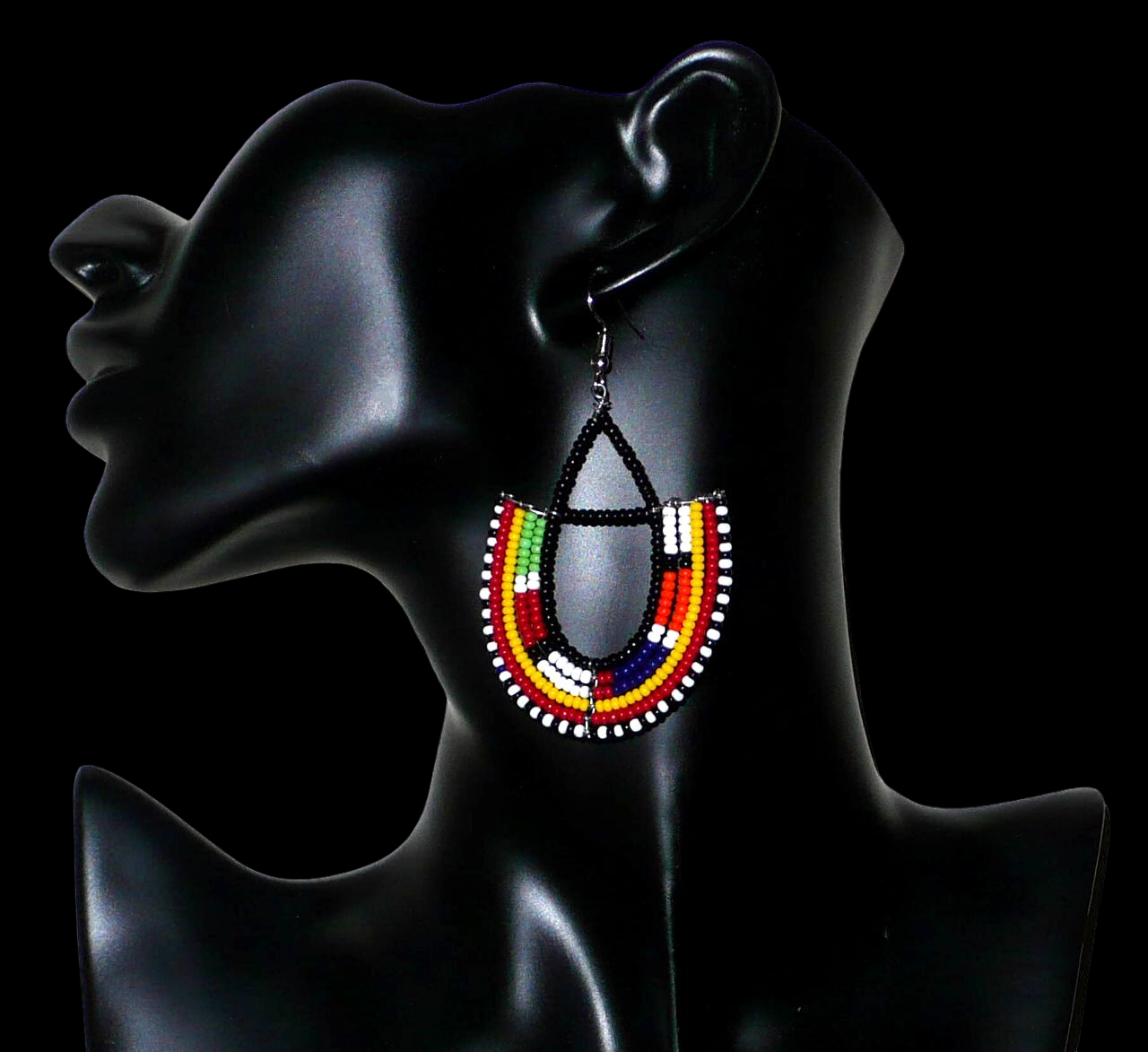 Boucles d'oreilles africaines traditionnelles fabriquées au Kenya par des femmes de la tribu Massai ; elles se composent de perles de rocaille noires et multicolores montées en forme d'ancres, et mesurent 7,5 cm de long et 4,5 cm de large. Elles se portent sur des oreilles percées avec des crochets en acier inoxydable.