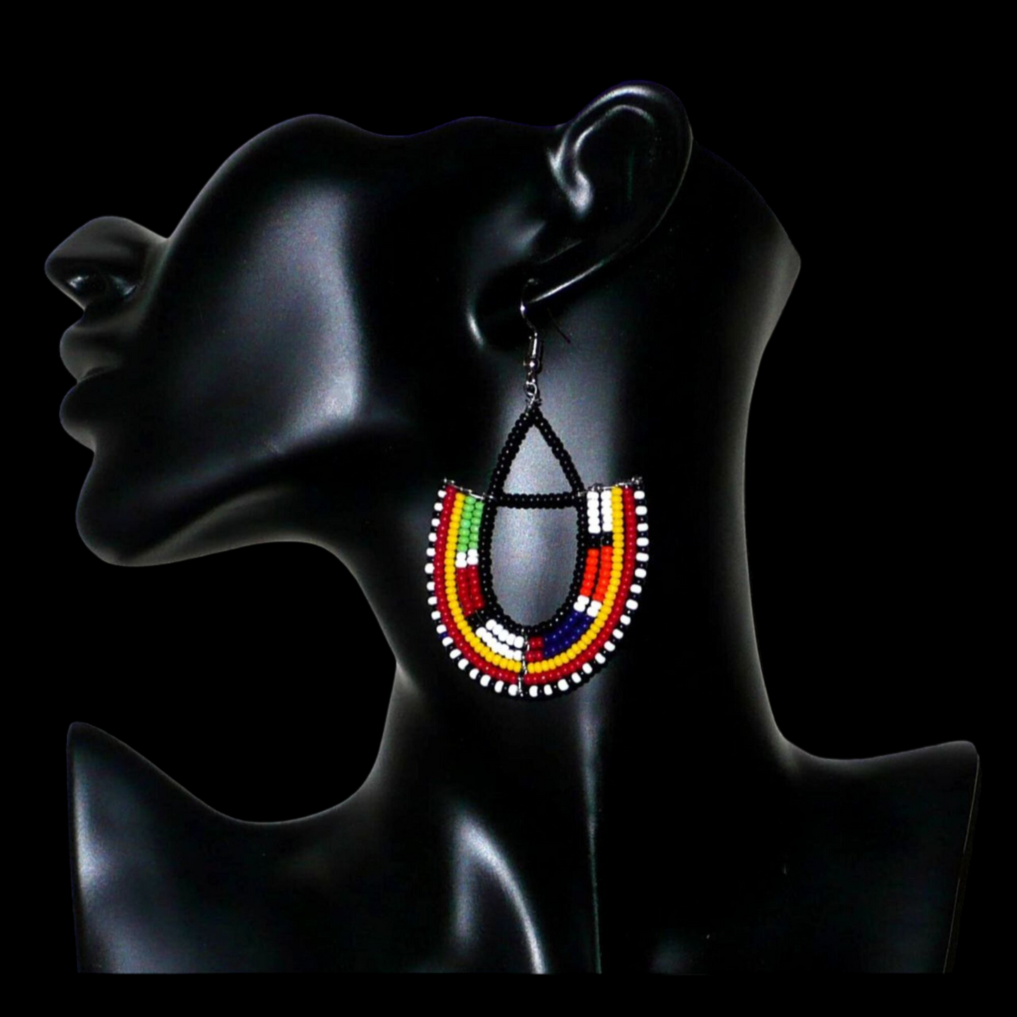 Boucles d'oreilles africaines traditionnelles fabriquées au Kenya par des femmes de la tribu Massai ; elles se composent de perles de rocaille noires et multicolores montées en forme d'ancres, et mesurent 7,5 cm de long et 4,5 cm de large. Elles se portent sur des oreilles percées avec des crochets en acier inoxydable.