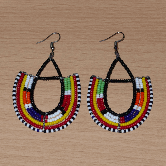 Boucles d'oreilles africaines traditionnelles fabriquées au Kenya par des femmes de la tribu Massai ; elles se composent de perles de rocaille noires et multicolores montées en forme d'ancres, et mesurent 7,5 cm de long et 4,5 cm de large. Elles se portent sur des oreilles percées avec des crochets en acier inoxydable.