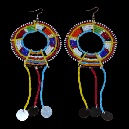 Boucles d'oreilles africaines multicolores confectionnées au Kenya dans la plus pure tradition tribale Massai. Elles se composent de perles de rocaille multicolores glissées sur des fils de fer montés en cercles fixés sur des charnières en plastique jaune, et se prolongent de franges perlées ornées de disques en métal. Surdimensionnées, ces longues boucles d'oreilles ethniques au style résolument afro mesurent 15 cm de long et se portent sur des oreilles percées.