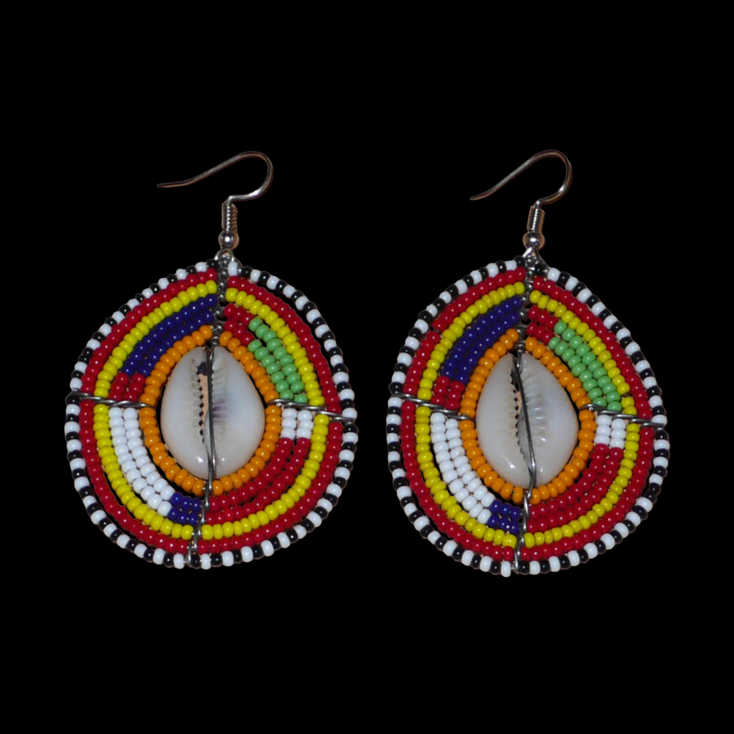 Boucles d'oreilles africaines à motifs ethniques traditionnels Massai composées de perles multicolores et de coquillages cauris ; elles mesurent 7 cm de long et 4 cm de large et se portent avec des crochets en acier inoxydable sur des oreilles percées.