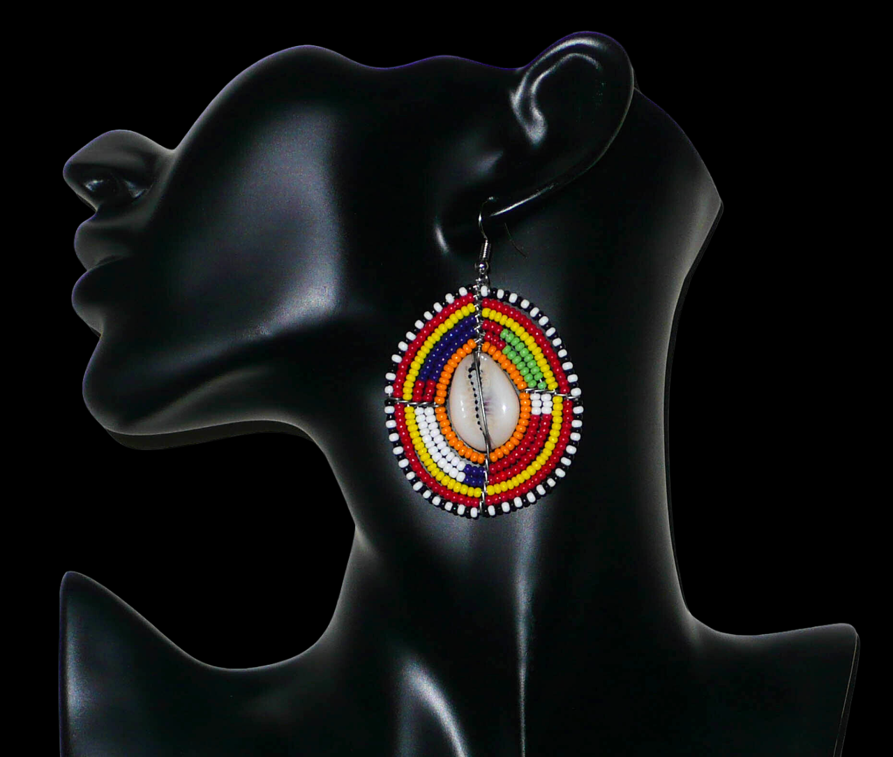 Boucles d'oreilles africaines à motifs ethniques traditionnels Massai composées de perles multicolores et de coquillages cauris ; elles mesurent 7 cm de long et 4 cm de large et se portent avec des crochets en acier inoxydable sur des oreilles percées.