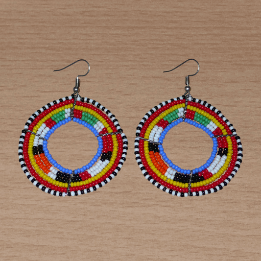 Boucles d'oreilles africaines traditionnelles Massai au style afro chic des années 70 composées de perles bleu et multicolores enfilées sur des structures circulaires en fils de fer. Elles mesurent 7 cm de long et 5 cm de large.