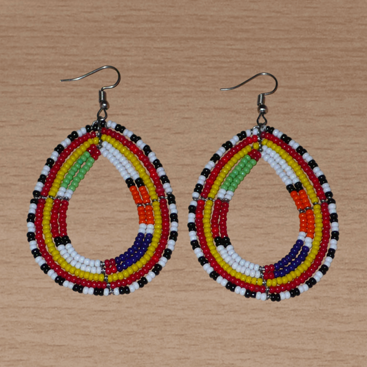 Apportez une touche de couleur à votre style avec ces boucles d'oreilles africaines issues de la tradition artisanale Massai : confectionnées avec des perles de rocaille multicolores montées en forme gouttes, elles sont parfaites pour sublimer votre look au quotidien ou lors d'occasions spéciales. Ces boucles d'oreilles colorées aux accents ethniques afro chic mesurent 8 cm de long et 4.5 cm de large ; elles se portent avec des crochets en acier inoxydable sur des oreilles percées.