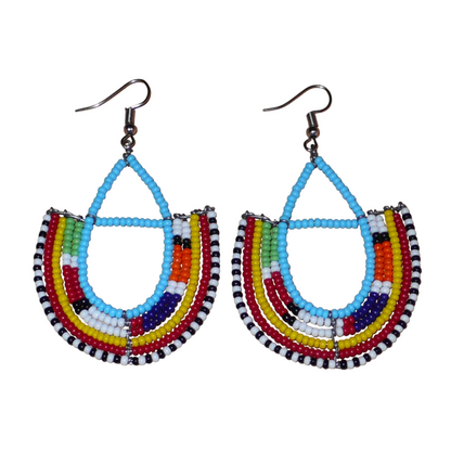 Boucles d'oreilles ethniques Massai bleues et multicolores en perles de rocaille montées en forme d'ancres. Elles mesurent 7.5 cm de long et se portent sur des oreilles percées.