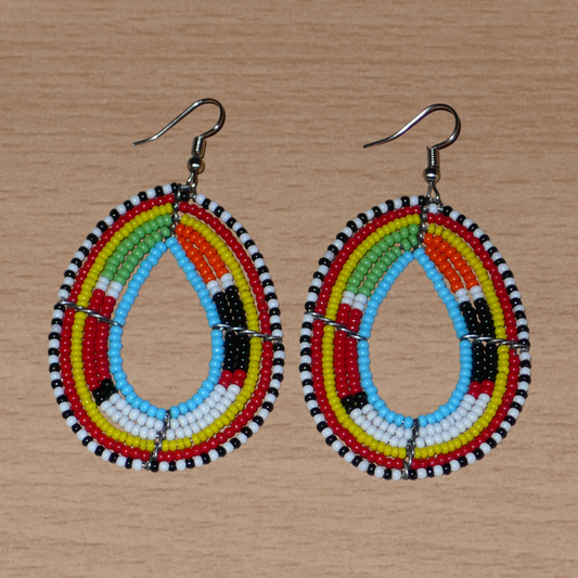 Boucles d'oreilles africaines ethniques de tradition Massai composées de perles de rocaille bleu ciel et multicolores montées en forme de gouttes. Elles mesurent 7.5 cm de long et 4 cm de large et se portent sur des oreilles percées.