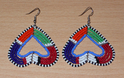 Boucles d'oreilles africaines kenyanes de fabrication artisanale Massai composées de perles de rocaille multicolores glissées sur cinq rangées de fils de fer montés en forme de cœurs inversés. Cette paire de boucles d'oreilles de taille moyenne mesure 6.5 cm de long et 5 cm de large ; elle se porte avec des crochets en acier inoxydable sur des oreilles percées.