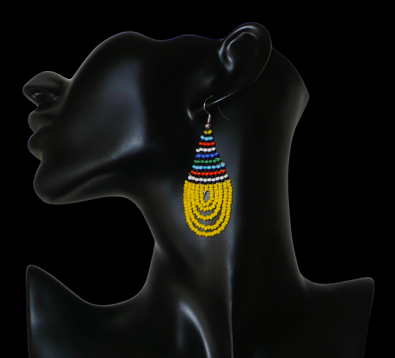 Boucles d'oreilles africaines traditionnelles zouloues en forme de gouttes composées d'un tissage de perles de rocaille jaunes et multicolores. Elles mesurent 7 cm de long et 2,5 cm de large et se portent sur des oreilles percées.