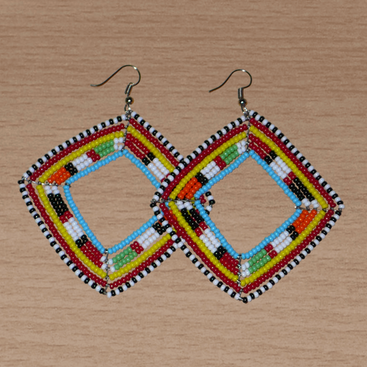 Longues et larges boucles d'oreilles africaines de tradition Massai en perles de rocaille multicolores. Elles mesurent 8.5 cm de long et 7 cm de large et se portent sur des oreilles percées.