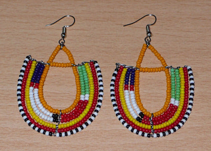 Boucles d'oreilles tribales Massai en forme d'ancres composées de perles orange et multicolores. Elles mesurent 7,5 cm de long et 4,5 cm de large.