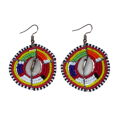 Boucles d'oreilles africaines traditionnelles en forme de boucliers Massai composées de perles de rocaille rouges et multicolores et de coquillages. De taille moyenne, elles mesurent 6 cm de long et 4 cm de large, et se portent avec des crochets en acier inoxydable sur des oreilles percées.