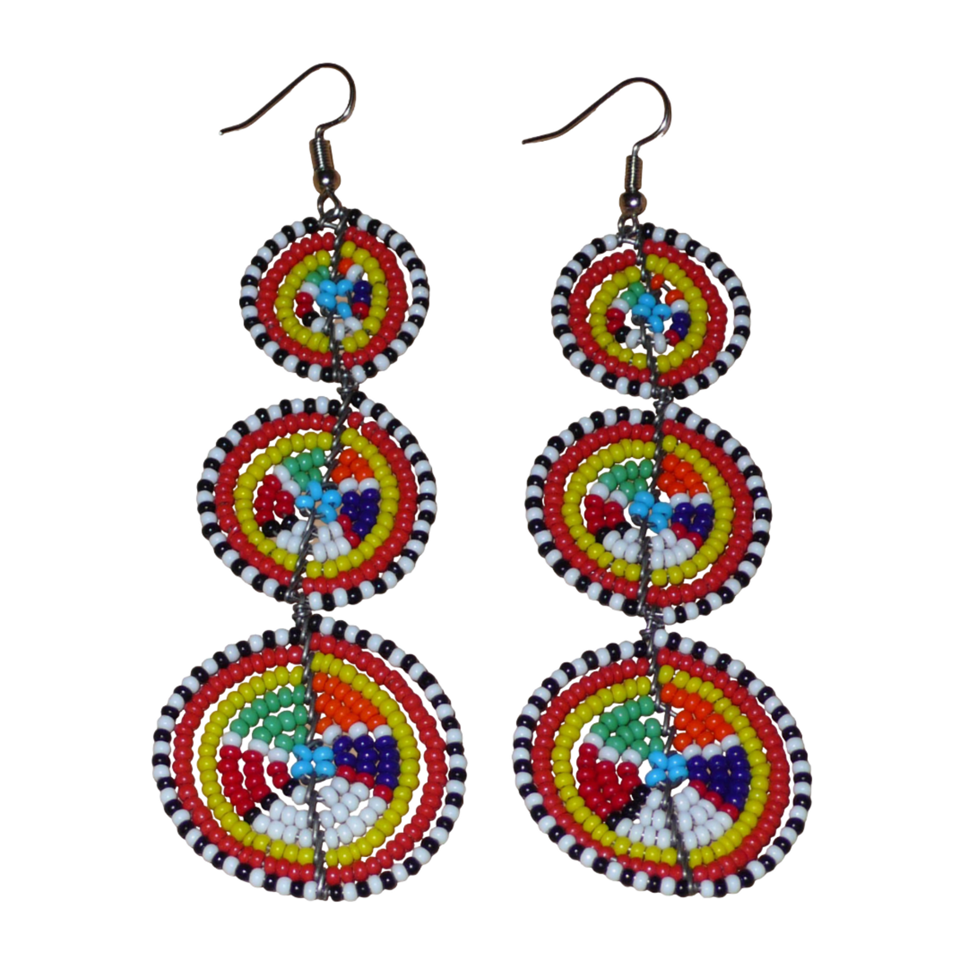 Ajoutez une note colorée évoquant le style ethnique afro chic des années 70 à votre look, avec cette paire de boucles d'oreilles africaines traditionnelles de confection artisanale Massai. Elles se composent de perles de rocaille multicolores glissées sur des fils de fer montés en forme de trois cercles superposés. Ces boucles d'oreilles mesurent 10.5 cm de long et 3 cm de large, et elles se portent avec des crochets en acier inoxydable sur des oreilles percées. 